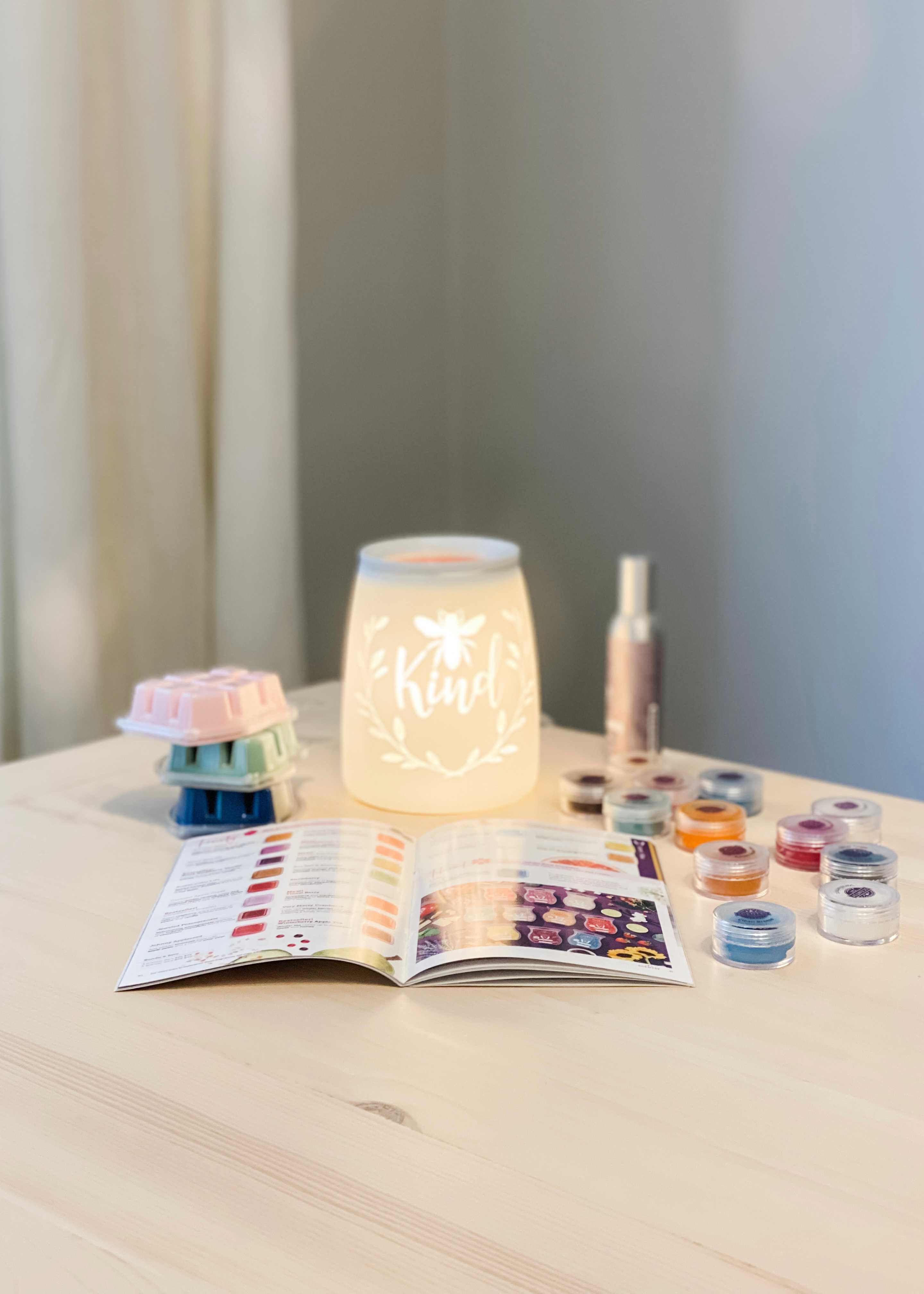 Picture of Scentsy catalog, warmer, wax, and testers on table